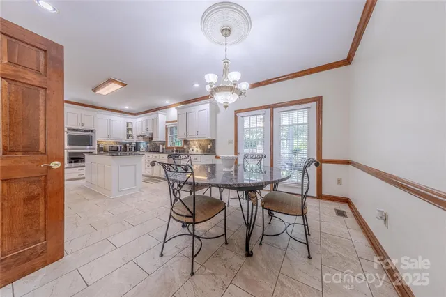 a view of a dining room with furniture and a chandelier