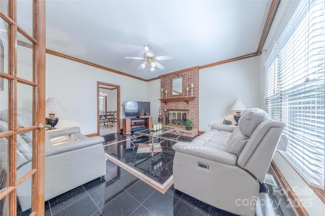 a living room with furniture a fireplace and a large window