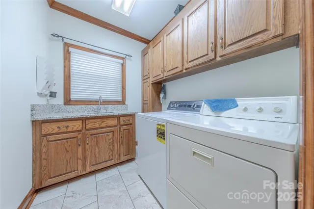 a utility room with granite countertop cabinets washer and dryer