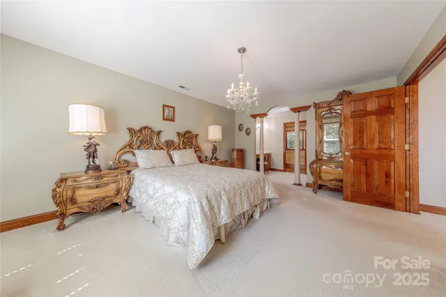 a spacious bedroom with a bed and a chandelier