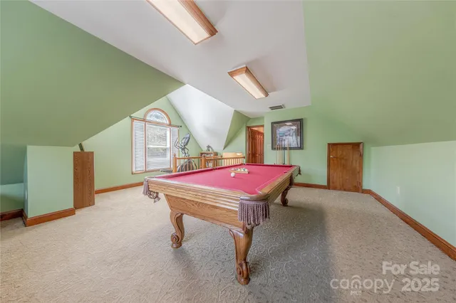 a room with furniture pool table and window