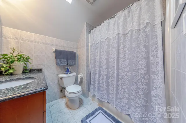 a bathroom with a granite countertop toilet and a sink