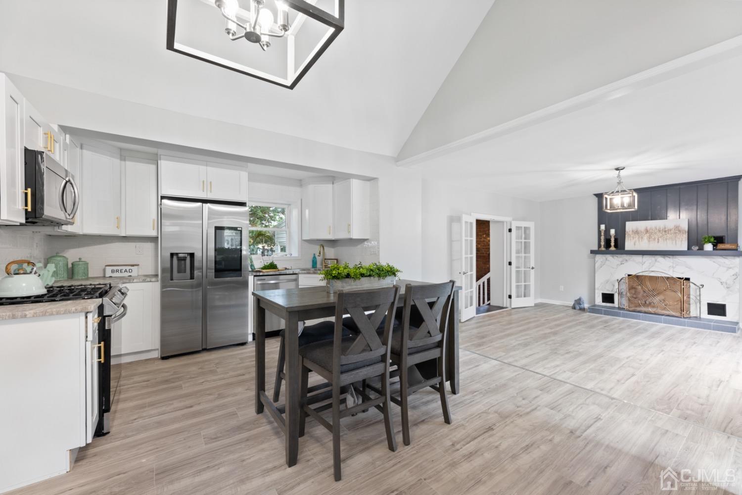 a kitchen with stainless steel appliances a table chairs refrigerator and a sink