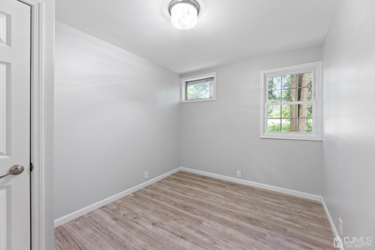 257 Matawan Avenue Matawan, NJ 07747 - Photo 19 of 28 an empty room with wooden floor and windows