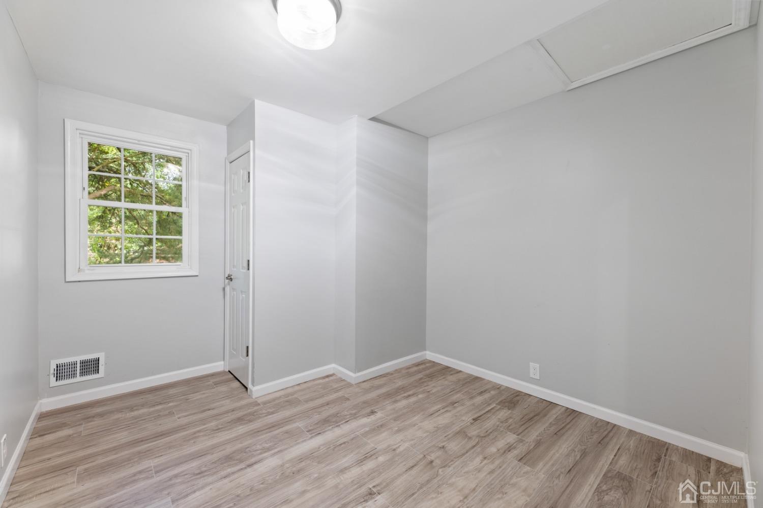 257 Matawan Avenue Matawan, NJ 07747 - Photo 20 of 28 an empty room with wooden floor and windows