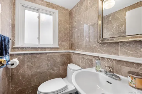 a bathroom with a sink a toilet and a mirror