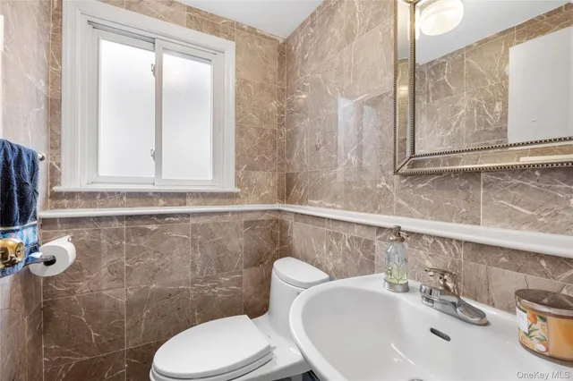 a bathroom with a sink a toilet and a mirror