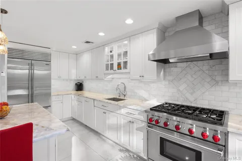 a kitchen with stainless steel appliances a stove a sink and a refrigerator