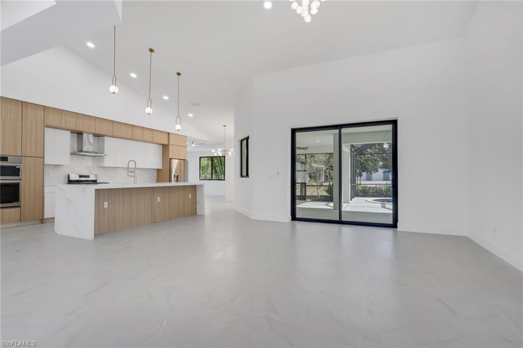 730 29th Street Southwest Naples, FL 34117 - Photo 50 of 50 Kitchen featuring modern cabinets, open floor plan, stainless steel appliances, dual tone cabinetry, and light stone counters