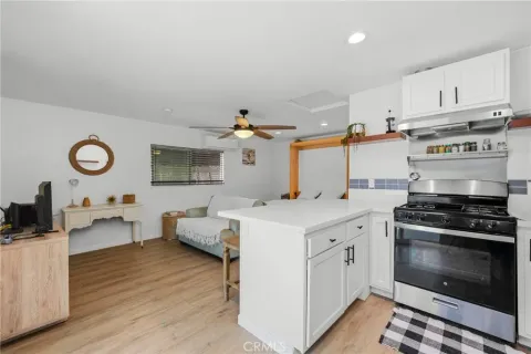 a kitchen with a stove and a wooden floor