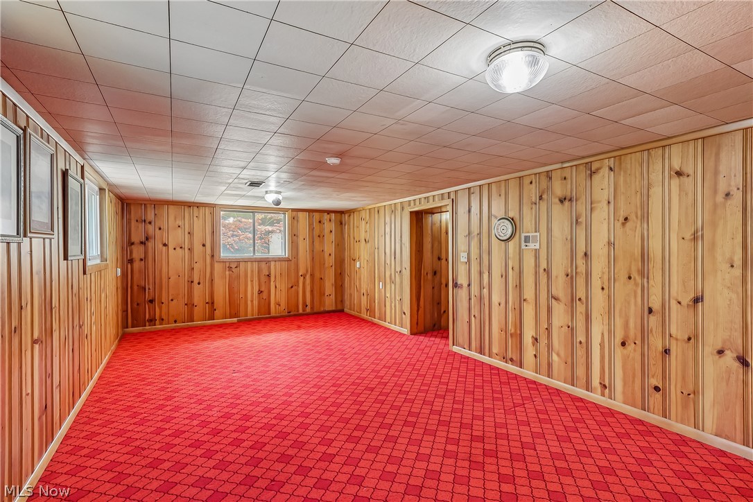 2060 6th Street Southwest Akron, OH 44314 - Photo 27 of 46 Lower level family room with knotty pine walls and carpet flooring