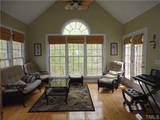 5000 Perception Lane Raleigh, NC 27613 - Photo 8 of 25 Sunroom has cathedral ceiling, hardwood floors and French doors to deck.