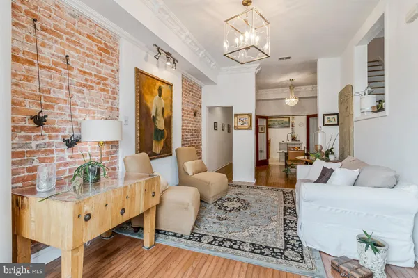 a living room with furniture wooden floor and a chandelier