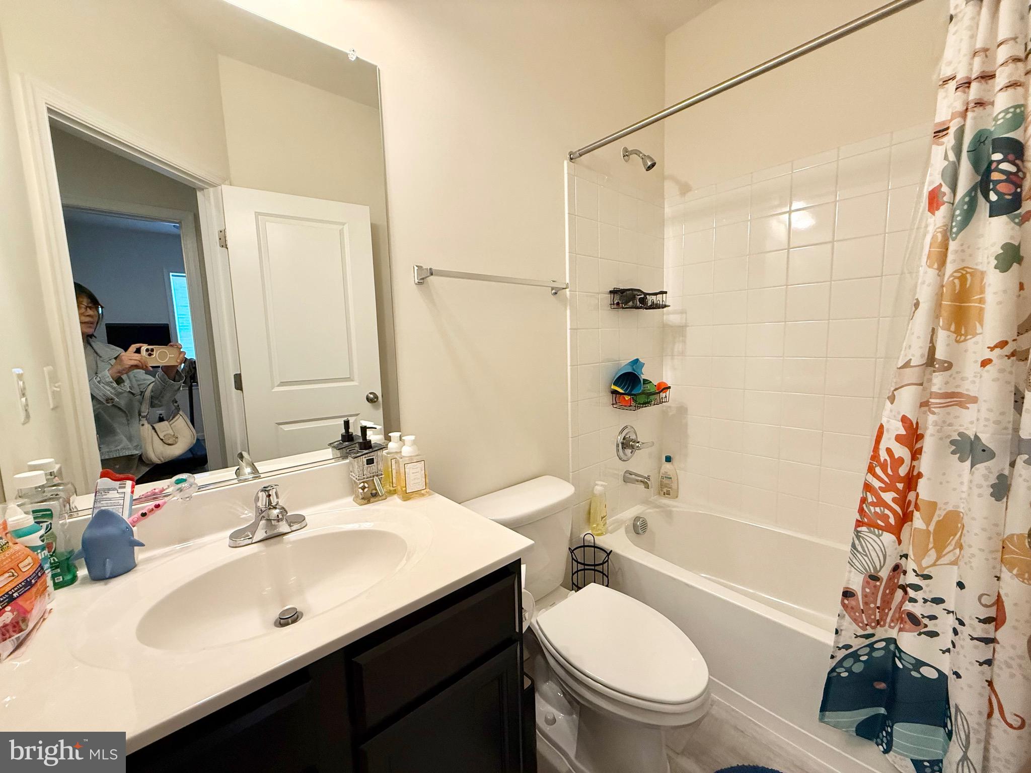 14327 Summit View Lane Rockville, MD 20850 - Photo 15 of 21 a bathroom with a sink a toilet a mirror a vanity and shower