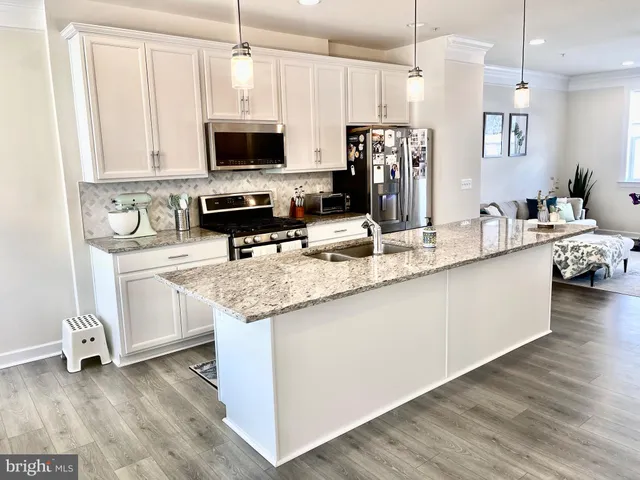 a kitchen with stainless steel appliances granite countertop a sink a stove and a microwave