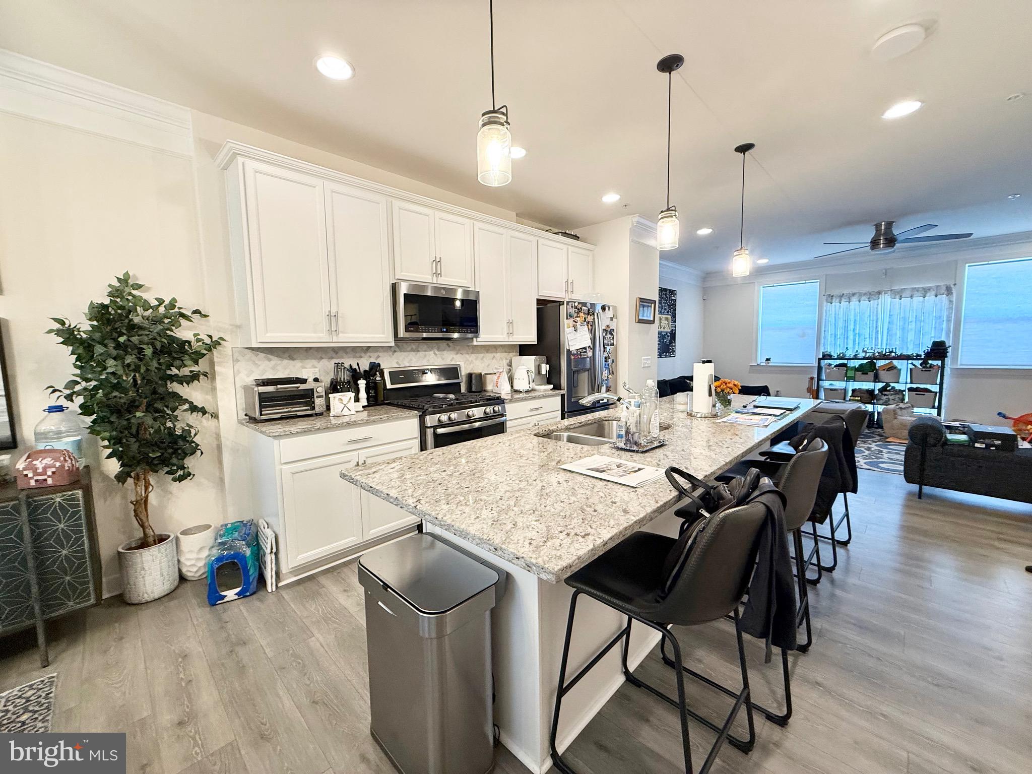 14327 Summit View Lane Rockville, MD 20850 - Photo 4 of 21 a kitchen with stainless steel appliances granite countertop a stove a refrigerator a sink a stove a dining table and chairs with wooden floor