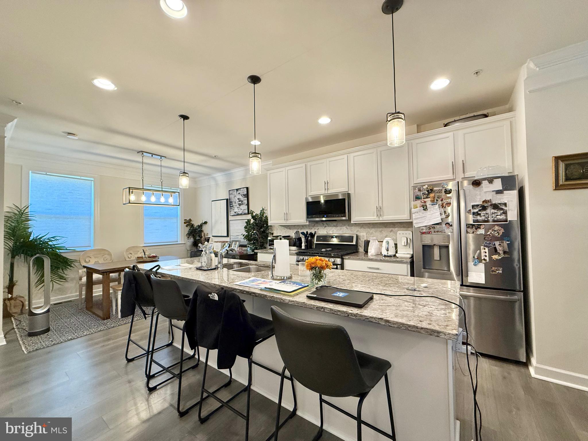 14327 Summit View Lane Rockville, MD 20850 - Photo 5 of 21 a kitchen with a dining table chairs refrigerator and microwave