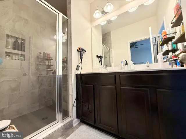 a bathroom with a sink mirror and shower