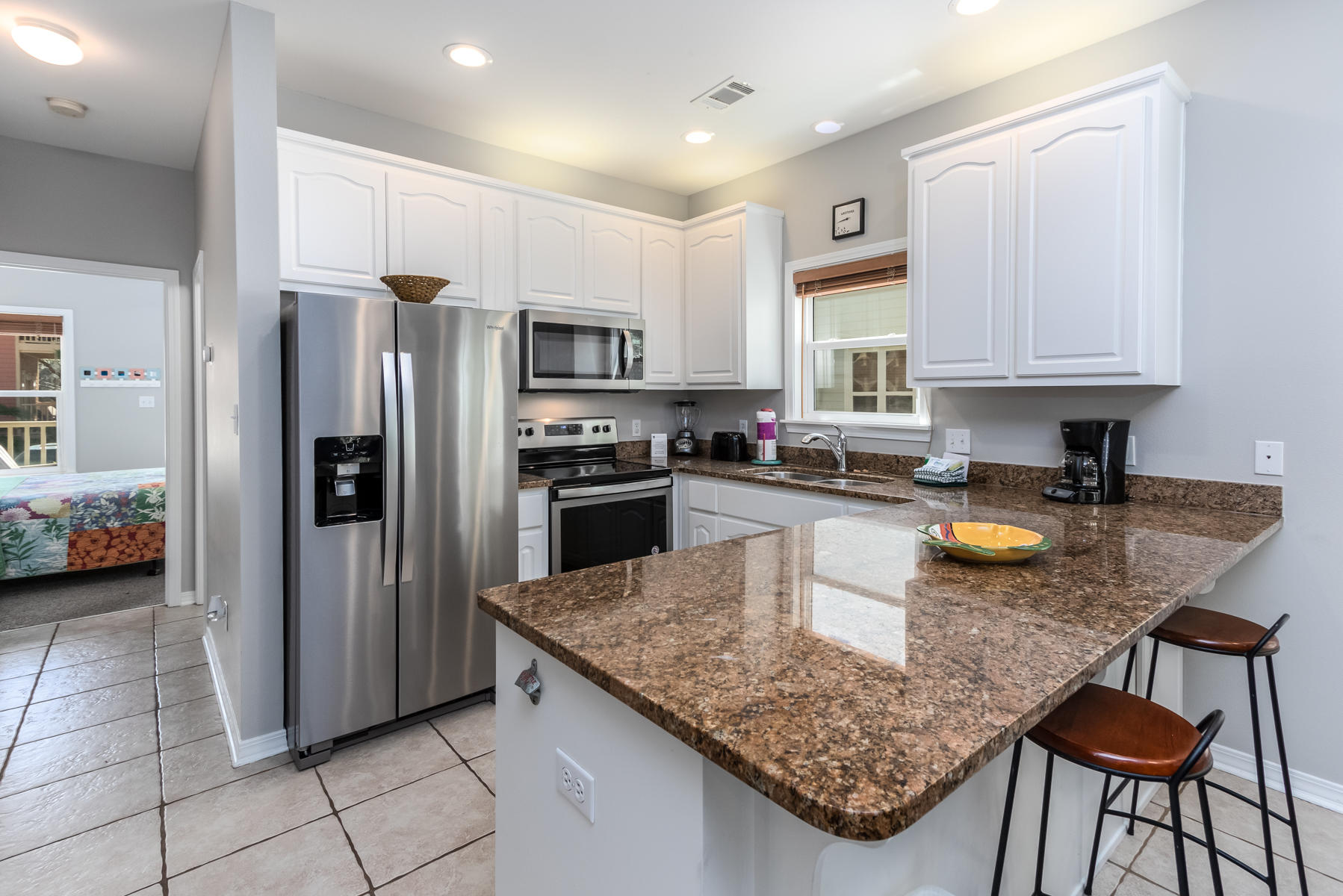 460 Hidden Lake Way Santa Rosa Beach, FL 32459 - Photo 20 of 40 a kitchen with stainless steel appliances granite countertop a stove a sink a microwave a refrigerator and white cabinets