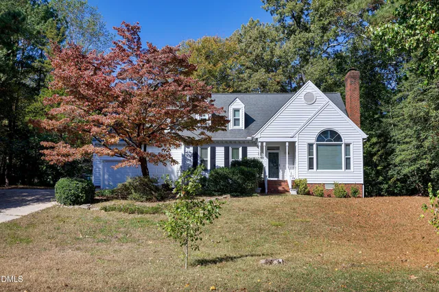 a front view of a house with a yard and trees