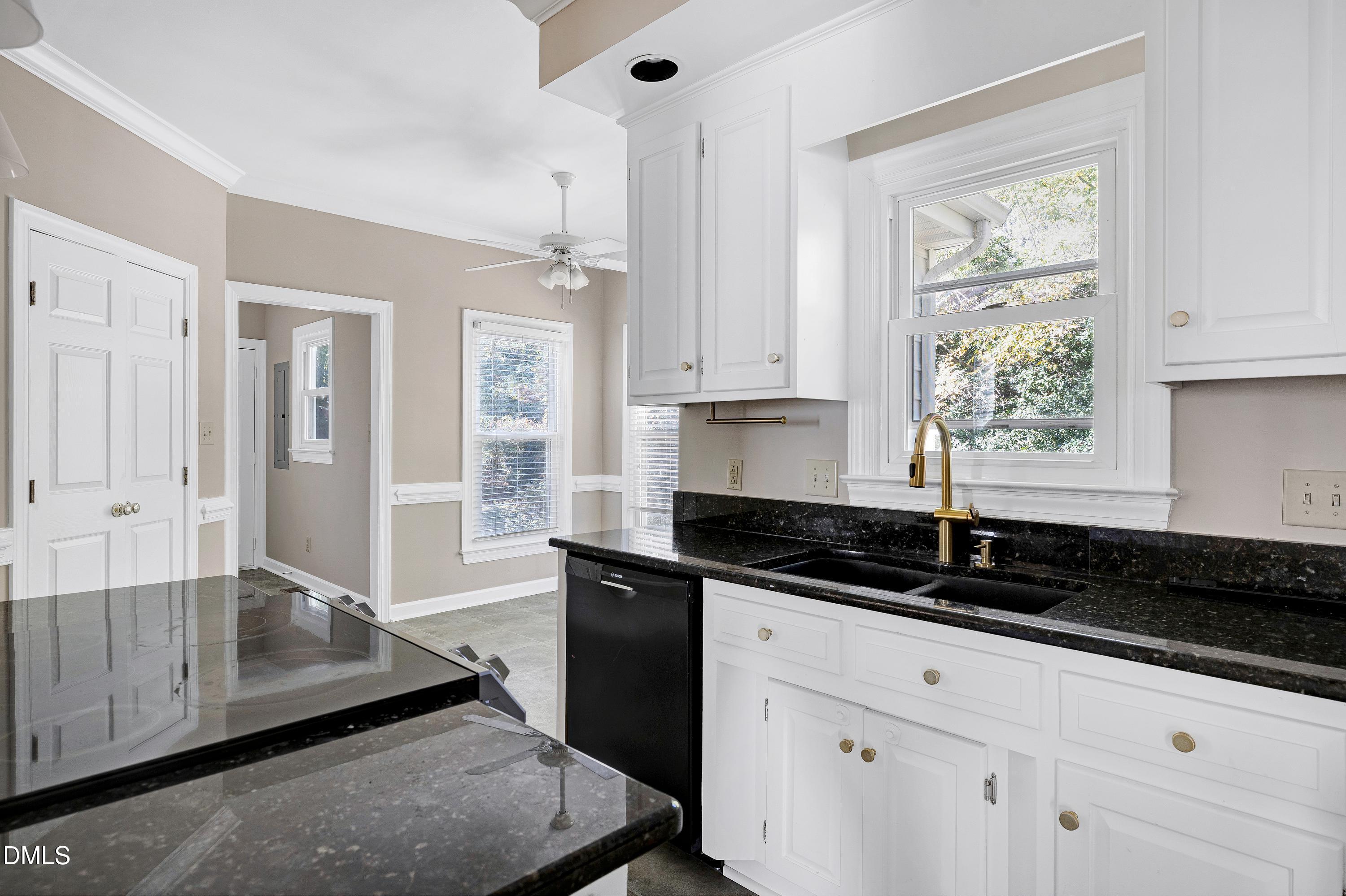 4804 Sinclair Drive Raleigh, NC 27616 - Photo 13 of 37 a kitchen with granite countertop white cabinets and black appliances
