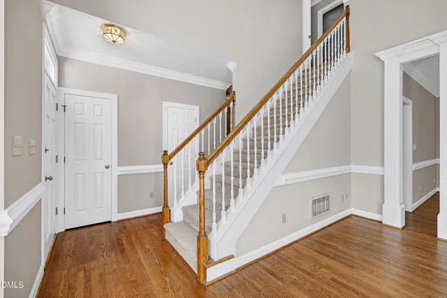 a view of front door with hallway and wooden floor