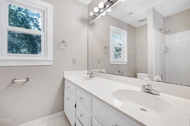 a bathroom with a double vanity sink and a mirror