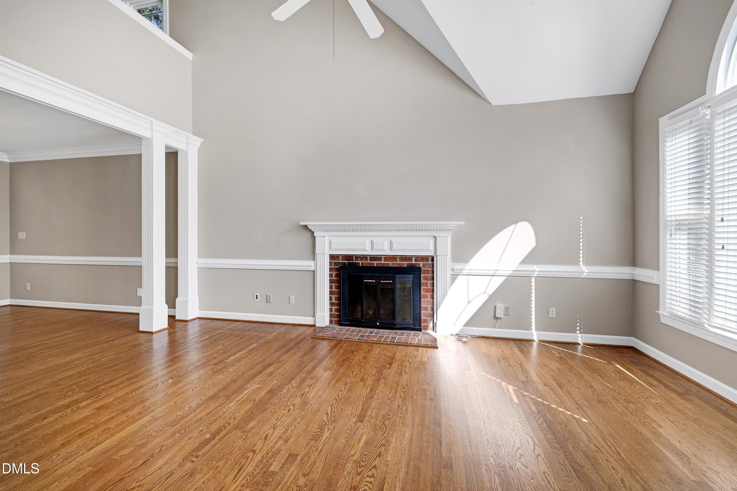 4804 Sinclair Drive Raleigh, NC 27616 - Photo 5 of 37 an empty room with wooden floor fireplace and windows