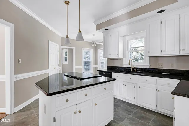 a kitchen with granite countertop white cabinets white appliances and a sink