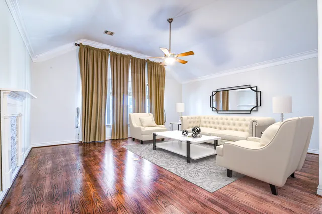 a living room with couches a flat screen tv and a large window