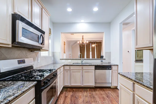a kitchen with stainless steel appliances granite countertop wooden cabinets stove top oven and sink