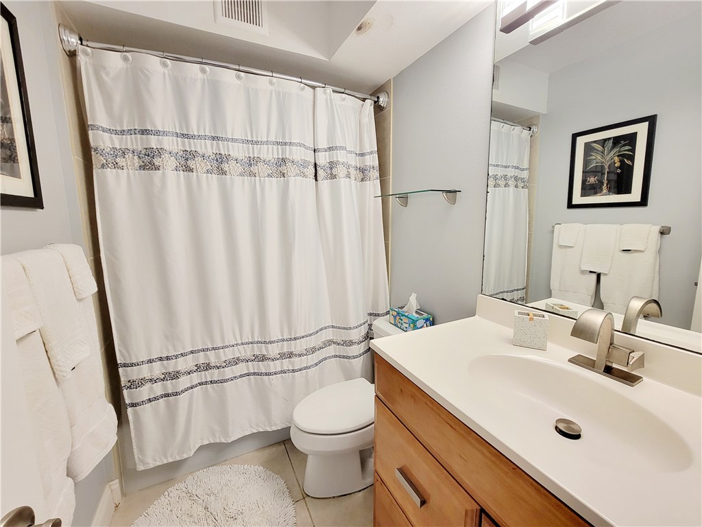 4450 Florida A1A, Unit 303 Vero Beach, FL 32963 - Photo 17 of 24 a bathroom with a sink a toilet and shower curtain