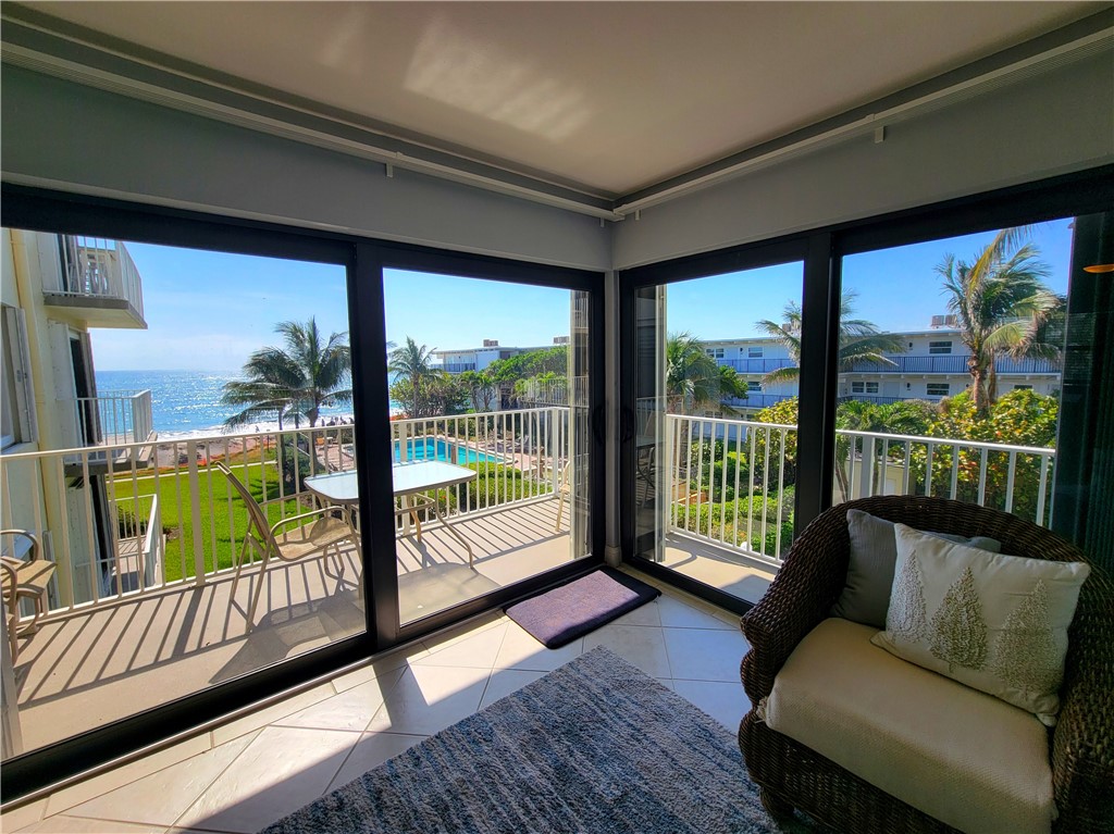 4450 Florida A1A, Unit 303 Vero Beach, FL 32963 - Photo 3 of 24 a living room with furniture and a floor to ceiling window