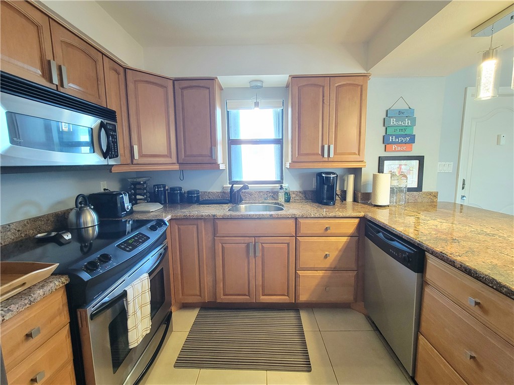 4450 Florida A1A, Unit 303 Vero Beach, FL 32963 - Photo 6 of 24 a kitchen with stainless steel appliances granite countertop a sink stove and cabinets