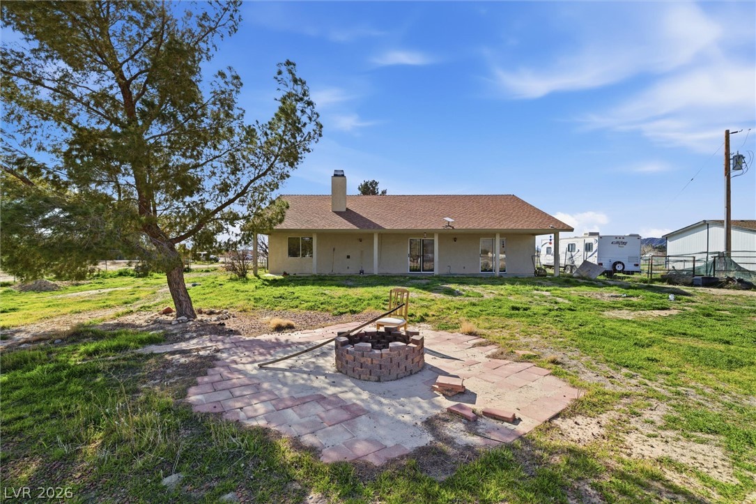 2780 West Simkins Road Pahrump, NV 89060 - Photo 36 of 40 A spacious backyard awaits, featuring a charming fire pit perfect for outdoor gatherings.