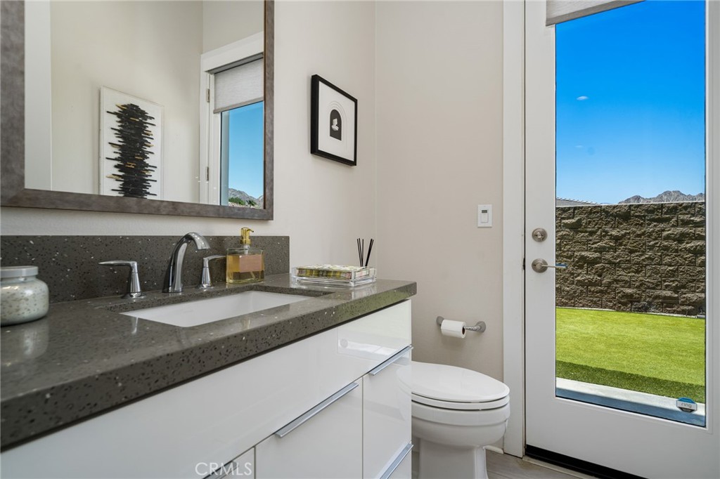 80380 Old Rnch Trail North La Quinta, CA 92253 - Photo 12 of 35 a bathroom with a granite countertop sink a toilet and a mirror