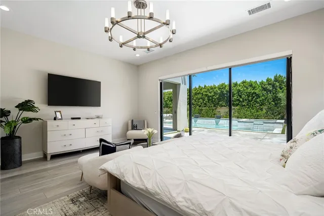 a bedroom with bed tv and window