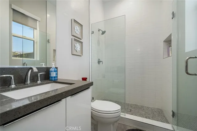 a bathroom with a granite countertop sink toilet and shower