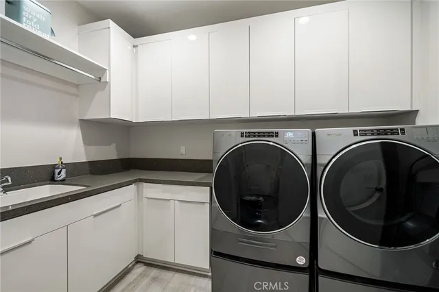 a utility room with sink dryer and washer
