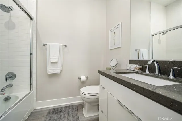 a bathroom with a granite countertop sink a toilet and shower