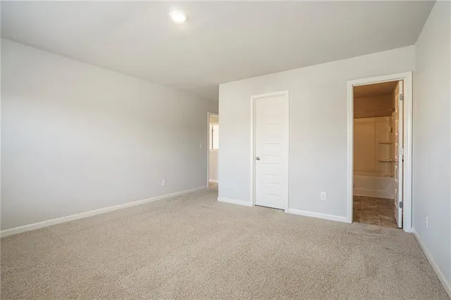 a spacious bedroom with a bed and a large window