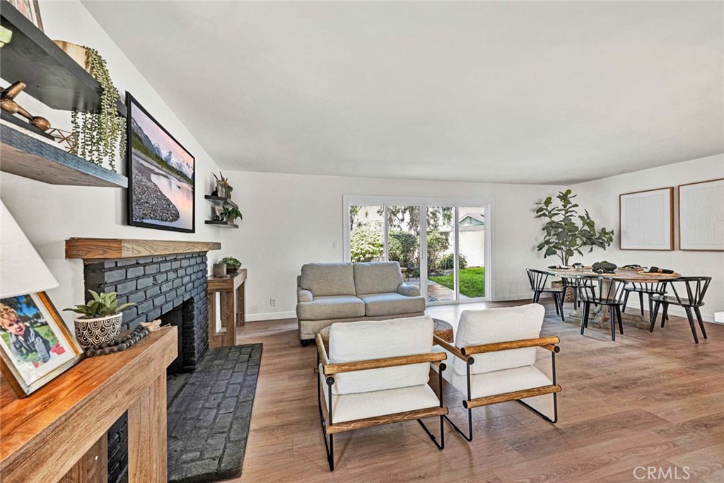 5331 Cerulean Avenue Garden Grove, CA 92845 - Photo 12 of 44 a living room with furniture a fireplace and a table with wooden floor