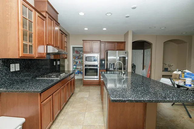 a kitchen with stainless steel appliances granite countertop a sink stove and cabinets