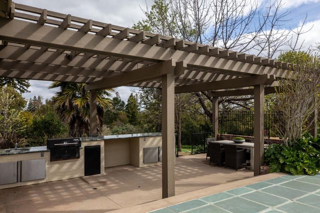 a view of a patio with a table and chairs under an umbrella with a big yard