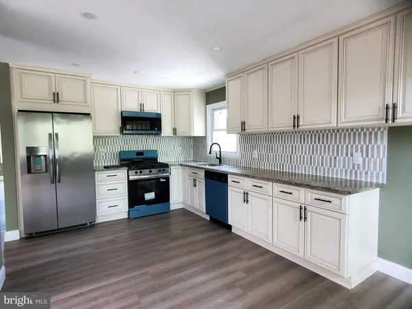 a kitchen with granite countertop white cabinets and stainless steel appliances