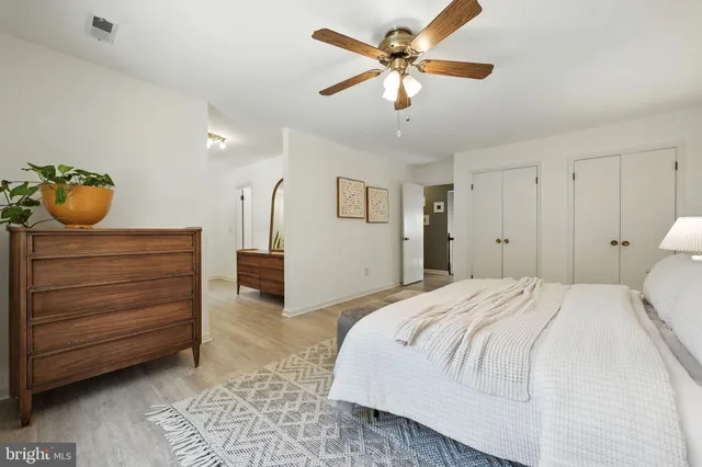 a spacious bedroom with a bed and a chandelier