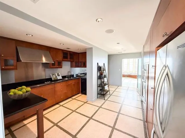 a kitchen with stainless steel appliances granite countertop a refrigerator and a sink