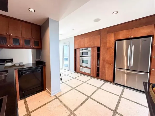 a kitchen with stainless steel appliances granite countertop a refrigerator and a stove top oven