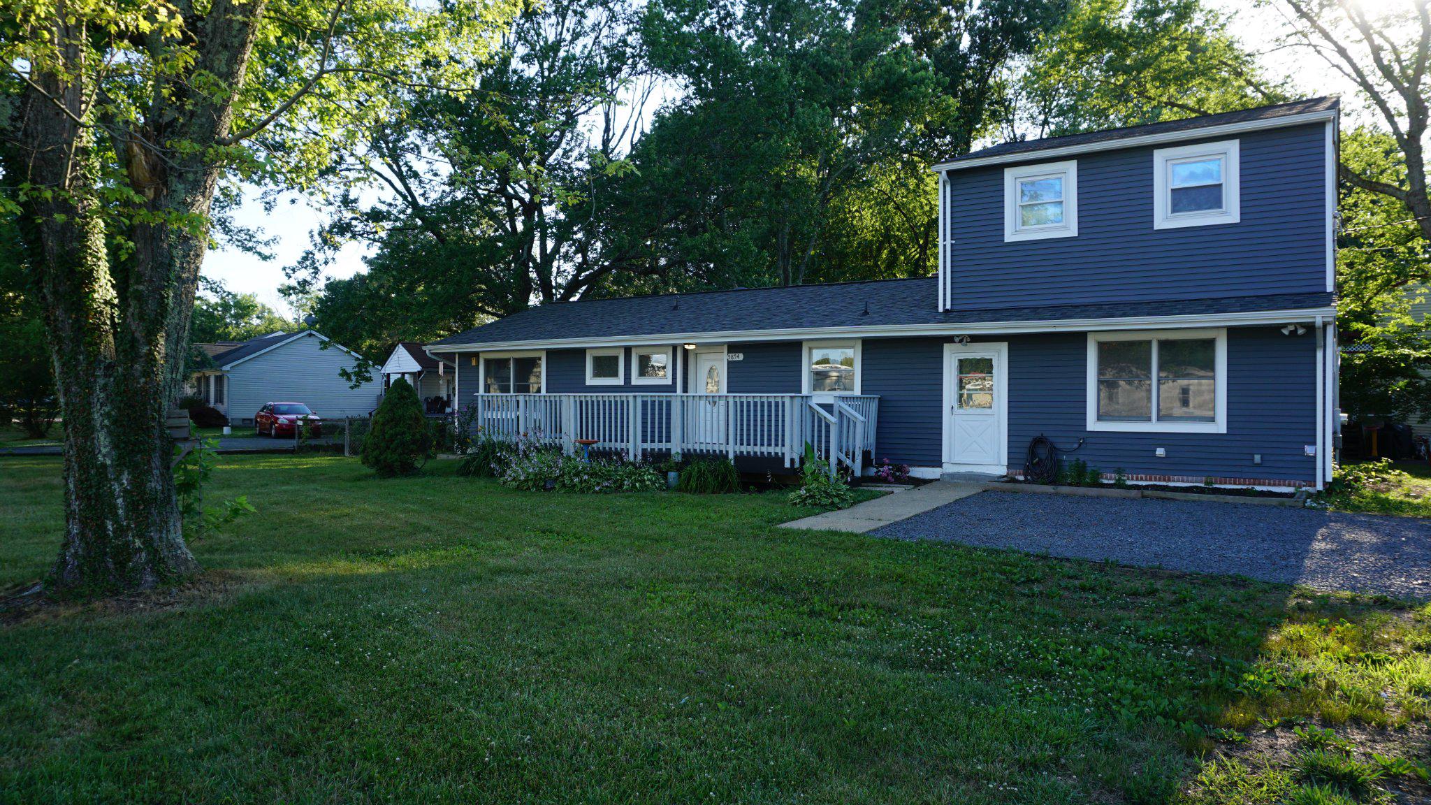 Charming blue Split Level home with lush greenery.