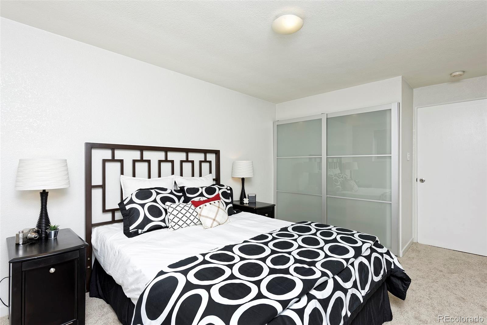 75 Emerson Street, Unit 103 Denver, CO 80218 - Photo 13 of 19 a bedroom with a large bed and a lamp